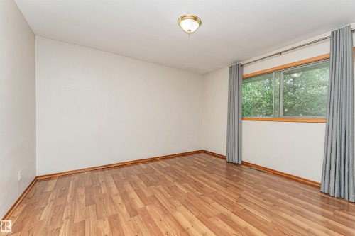 Wood-finish flooring with coordinating baseboards - 11139 62 Avenue Nw, Edmonton, AB - Indoor Photo Showing Other Room
