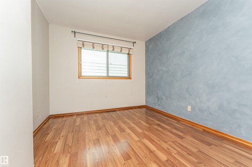 Wood-finish flooring, light-toned walls, and a window with wood trim - 11139 62 Avenue Nw, Edmonton, AB - Indoor Photo Showing Other Room