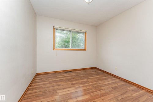 Wood-finish flooring with a natural wood-tone window frame and trim - 11139 62 Avenue Nw, Edmonton, AB - Indoor Photo Showing Other Room