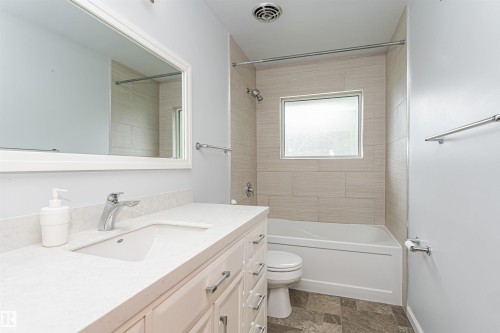 White vanity with a rectangular undermount sink, a chrome faucet, and a light-toned countertop - 11139 62 Avenue Nw, Edmonton, AB - Indoor Photo Showing Bathroom