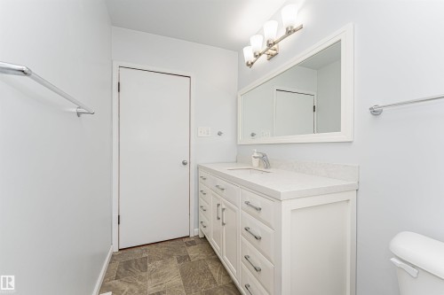 White vanity with brushed nickel hardware, integrated sink, and light-toned countertop - 11139 62 Avenue Nw, Edmonton, AB - Indoor Photo Showing Bathroom