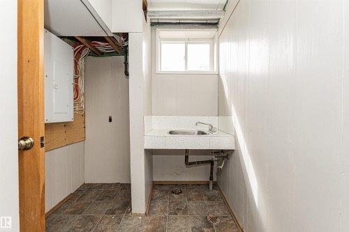 Utility room featuring a window, built-in sink, and paneling - 11139 62 Avenue Nw, Edmonton, AB - Indoor