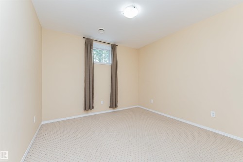 Neutral tone walls with patterned carpeting, overhead flush-mount lighting, and a single window - 11139 62 Avenue Nw, Edmonton, AB - Indoor Photo Showing Other Room