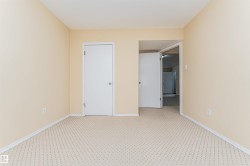 Neutral wall finishes with white trim, patterned carpet flooring, and multiple entryways - 