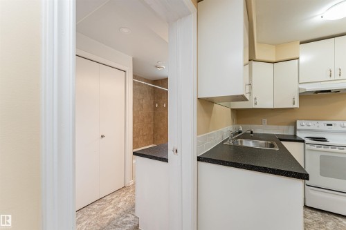 Kitchenette with white cabinetry, dark speckled countertops, and a stainless steel sink - 11139 62 Avenue Nw, Edmonton, AB - Indoor Photo Showing Kitchen