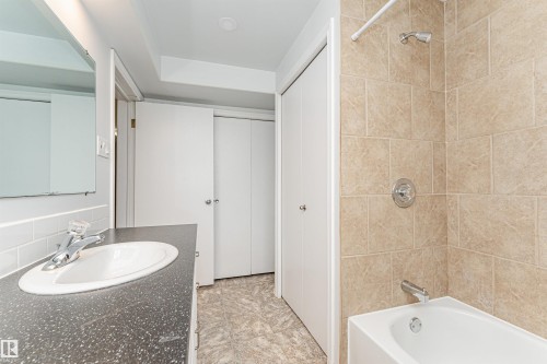Bathroom featuring a vanity with an integrated sink, a tiled backsplash, and a shower/tub combination with tiled surround - 11139 62 Avenue Nw, Edmonton, AB - Indoor Photo Showing Bathroom