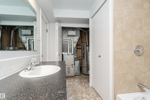 Vanity with integrated sink, speckled countertop, and white subway tile backsplash - 11139 62 Avenue Nw, Edmonton, AB - Indoor Photo Showing Bathroom