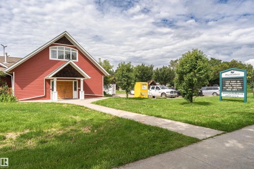 Gabled building with red siding, prominent window dormer, and wood double entry doors - 11139 62 Avenue Nw, Edmonton, AB - Outdoor