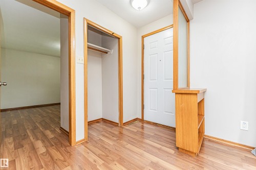 Wood-finish flooring throughout, white paneled entry door, built-in wooden shelving unit, and integrated ceiling light fixture - 11139 62 Avenue Nw, Edmonton, AB - Indoor Photo Showing Other Room