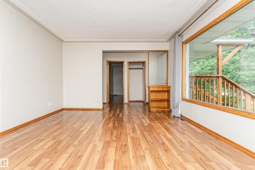 Wood-finish flooring throughout, large window with wood trim, built-in shelving, and neutral wall tones - 11139 62 Avenue Nw, Edmonton, AB - Indoor Photo Showing Other Room