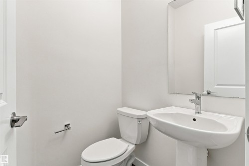 White pedestal sink with chrome faucet and rectangular mirror - 22019 82 Avenue Nw, Edmonton, AB - Indoor Photo Showing Bathroom