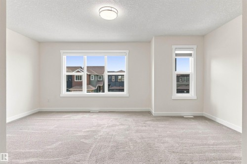 Neutral tone wall paint, carpet flooring, two windows, and a ceiling-mounted light fixture - 22019 82 Avenue Nw, Edmonton, AB - Indoor Photo Showing Other Room