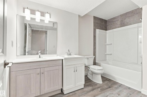 Dual vanity with rectangular sinks and chrome faucets, full-width mirror, and overhead lighting - 22019 82 Avenue Nw, Edmonton, AB - Indoor Photo Showing Bathroom