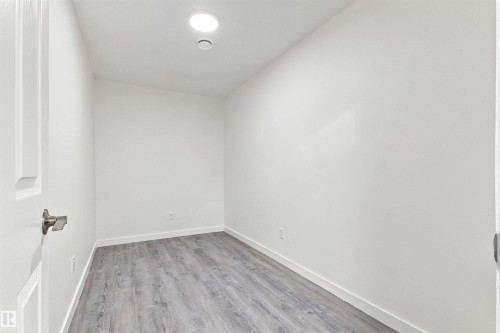 White walls, recessed ceiling light, wood-finish flooring, and white trim - 22019 82 Avenue Nw, Edmonton, AB - Indoor Photo Showing Other Room