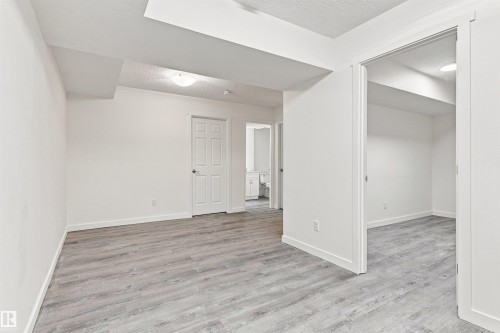 Spacious interior with wood-finish flooring, recessed lighting, and a neutral color palette - 22019 82 Avenue Nw, Edmonton, AB - Indoor Photo Showing Other Room