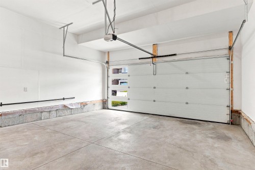 Overhead garage door with clear panels, finished concrete floor, and integrated garage door opener - 22019 82 Avenue Nw, Edmonton, AB - Indoor Photo Showing Garage