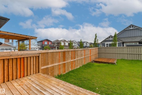 Expansive backyard featuring a wood deck, pergola, privacy fencing, a manicured lawn, and an additional wood platform - 22019 82 Avenue Nw, Edmonton, AB - Outdoor With Deck Patio Veranda
