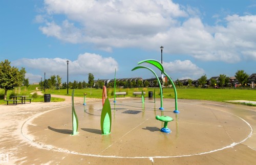 Splash pad with multiple water features, surrounded by expansive green space, paved pathways, and mature trees - 22019 82 Avenue Nw, Edmonton, AB - Outdoor With View