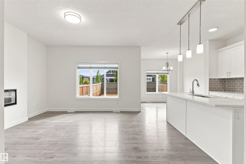 Open-concept living area featuring wood-finish flooring and an electric fireplace - 22019 82 Avenue Nw, Edmonton, AB - Indoor