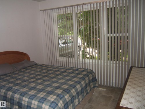 Double window with vertical blinds - 4809 47A Street, Two Hills, AB - Indoor Photo Showing Bedroom