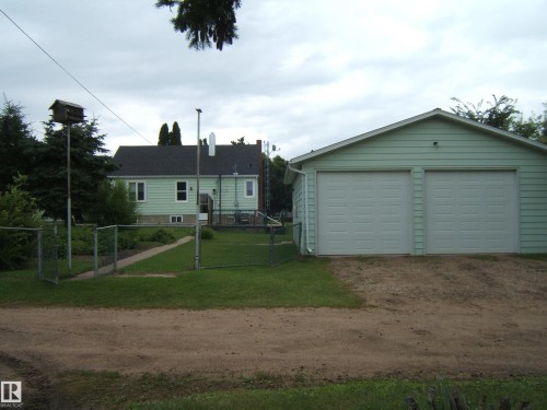 Two-car garage with panel doors and light green siding - 4809 47A Street, Two Hills, AB - Outdoor