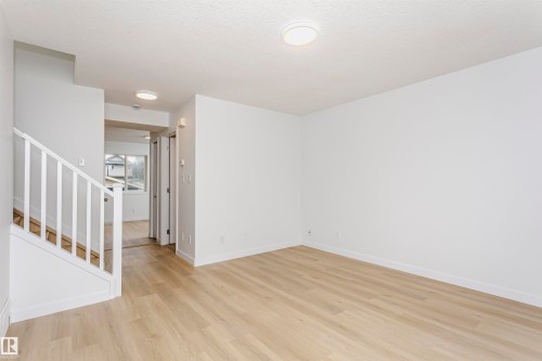 Bright, open loft space featuring warm wood-finish flooring, soaring ceilings with recessed lighting, and clean white walls - 37 Suntree Promenade, Leduc, AB - Indoor Photo Showing Other Room