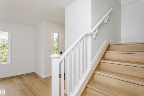 Staircase with wood-finish treads and risers, white painted balusters, and a white handrail - 37 Suntree Promenade, Leduc, AB - Indoor Photo Showing Other Room