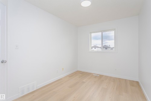 Recessed ceiling light, white walls, wood-finish flooring, and a window with white trim - 37 Suntree Promenade, Leduc, AB - Indoor Photo Showing Other Room