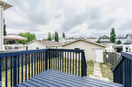 Wood deck with dark-stained railing, leading to a fenced backyard - 37 Suntree Promenade, Leduc, AB - Outdoor With Deck Patio Veranda With Exterior