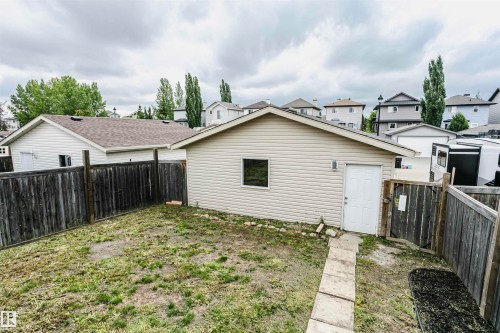 Fenced backyard featuring a detached accessory structure with siding, a single window, and a white door - 37 Suntree Promenade, Leduc, AB - Outdoor With Exterior
