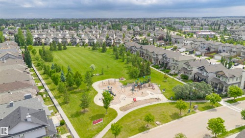 Expansive green space featuring a playground, mature trees, and paved pathways - 37 Suntree Promenade, Leduc, AB - Outdoor With View
