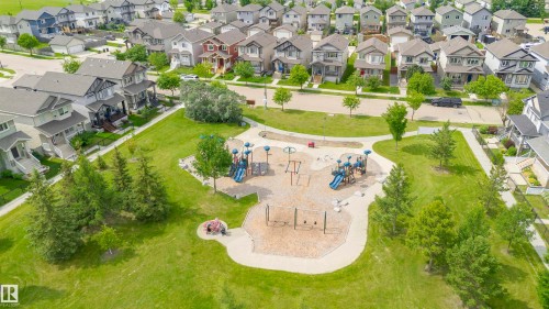 Expansive green space featuring a playground, paved pathways, and mature trees - 37 Suntree Promenade, Leduc, AB - Outdoor With View