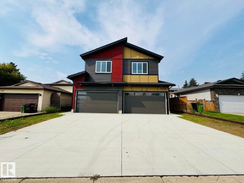 Contemporary facade with multiple siding textures and colors, two separate attached garages, and a concrete driveway - 1312 35 Street Nw, Edmonton, AB 