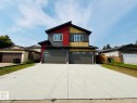 Contemporary facade with multiple siding textures and colors, two separate attached garages, and a concrete driveway - 1312 35 Street Nw, Edmonton, AB 
