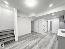 Light wood-finish flooring throughout, recessed lighting, and a contemporary flush-mount ceiling fixture - 