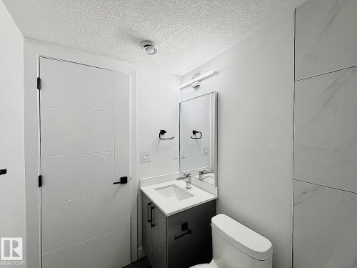 Integrated vanity with a rectangular basin sink, chrome faucet, and quartz countertop - 1312 35 Street Nw, Edmonton, AB 
