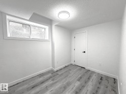 Recessed window, ceiling-mounted light fixture, wood-finish flooring, white painted walls, white door with black hardware - 