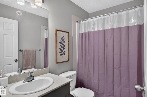 Bathroom featuring a vanity with an integrated sink, polished chrome faucet, and a wall-mounted mirror - 17 Spruce Ridge Cove, Spruce Grove, AB - Indoor Photo Showing Bathroom