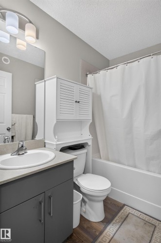 Modern bathroom featuring a dark charcoal vanity with dual handles, white ceramic round sink, and brushed nickel faucet - 17 Spruce Ridge Cove, Spruce Grove, AB - Indoor Photo Showing Bathroom
