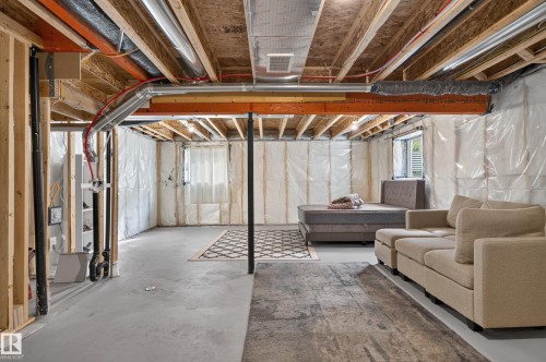Finished Basement with Exposed Wood Beam Ceiling and Polished Concrete Flooring - 17 Spruce Ridge Cove, Spruce Grove, AB - Indoor Photo Showing Basement