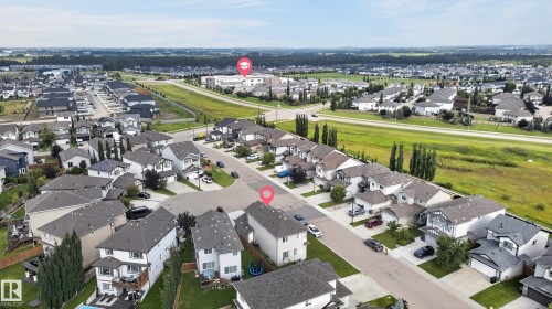 Aerial view showcasing a newly developed residential community featuring contemporary homes with modern architectural design, manicured lawns, and tree-lined streetscapes - 17 Spruce Ridge Cove, Spruce Grove, AB - Outdoor With View