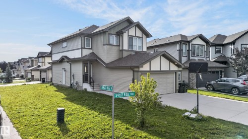 Two-story home featuring a transitional exterior with mixed siding and stone accents, arched entryway detail, and a two-car attached garage - 17 Spruce Ridge Cove, Spruce Grove, AB - Outdoor