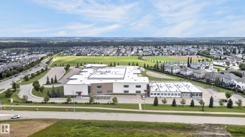 Modern industrial facility featuring a clean-lined white exterior with extensive glazing, positioned on expansive manicured grounds - 17 Spruce Ridge Cove, Spruce Grove, AB - Outdoor With View
