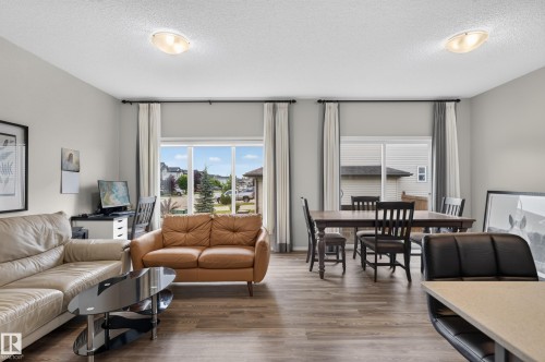 Bright, open-concept living space featuring recessed ceiling lighting, large multi-pane windows with operable shutters, and wood-finish flooring throughout - 17 Spruce Ridge Cove, Spruce Grove, AB - Indoor Photo Showing Living Room