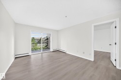 Spacious room featuring wood-finish flooring, white baseboards, and light-toned walls - 