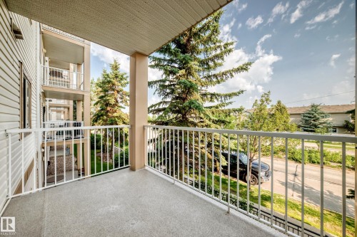 Private balcony with textured concrete flooring and a white metal railing - #214 245 Edwards Dr Sw, Edmonton, AB - Outdoor With Balcony With Exterior