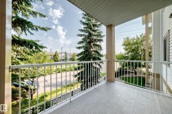 Private balcony featuring a textured concrete floor and white metal railings - 