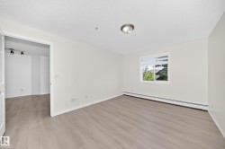 Room featuring wood-finish flooring, a contemporary ceiling light fixture, and a window with natural light - 