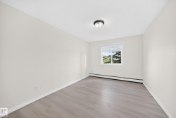 Room featuring light gray wood-finish flooring, white baseboards, and neutral wall paint - 
