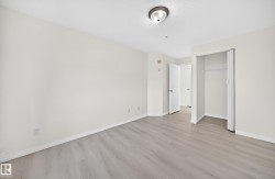 Spacious interior room featuring light wood-finish flooring, white baseboards, and neutral wall paint - 